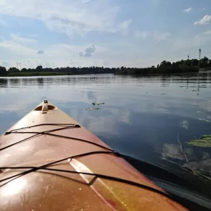 Dzeltens kajaks Daugavā saulainā dienā.